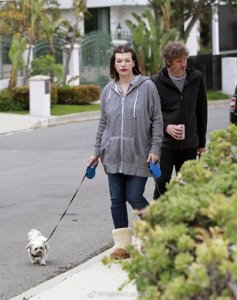 ​米拉·乔沃维奇和老公遛狗，因刚生下第三个女儿，状态比较憔悴